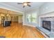 Open-concept living room showcases hardwood floors, stone fireplace, and seamless flow into the kitchen area at 410 Wicklow St, Tyrone, GA 30290
