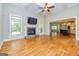 Open living room featuring fireplace, hardwood floors, and ceiling fan at 410 Wicklow St, Tyrone, GA 30290