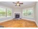 Bright living room with hardwood floors, stone fireplace, neutral walls, and a ceiling fan at 410 Wicklow St, Tyrone, GA 30290