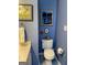 Bathroom featuring a toilet, sink, and blue walls adorned with artwork at 411 Sherrels Frd, Peachtree City, GA 30269