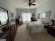Bright bedroom with warm lighting, a plush bed, dresser, and a large window at 411 Sherrels Frd, Peachtree City, GA 30269