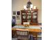 Traditional dining room boasts wooden table, chairs, china cabinet, and stylish light fixture at 411 Sherrels Frd, Peachtree City, GA 30269