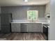 Bright kitchen featuring stainless steel appliances, wood floor, light gray cabinetry, and marble-style countertops at 30 Laurel Way, Covington, GA 30016