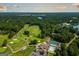 Scenic aerial view of a golf course, lake, and community beach area surrounded by lush greenery at 5133 Woodmond Dr, Villa Rica, GA 30180