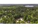 Stunning aerial view of a wooded property with a beautiful home and lake nearby at 5133 Woodmond Dr, Villa Rica, GA 30180
