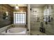 Bathroom boasts soaking tub, walk-in shower, and wood accent wall adding a touch of rustic elegance at 5133 Woodmond Dr, Villa Rica, GA 30180