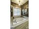 Luxurious bathroom features soaking tub with wood accent wall, creating a serene and inviting retreat at 5133 Woodmond Dr, Villa Rica, GA 30180
