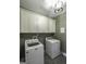 Well-lit laundry room featuring neutral cabinets, modern fixtures, and appliances for a seamless laundry experience at 5133 Woodmond Dr, Villa Rica, GA 30180