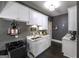 Well-lit laundry room featuring white cabinets, marble countertops, and a stainless steel sink at 5133 Woodmond Dr, Villa Rica, GA 30180