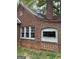 A brick wall with a satellite dish mounted, featuring classic white-framed windows with decorative burglar bars at 250 Mathewson Sw Pl, Atlanta, GA 30314