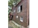 View of rear of red brick house in need of repair, including stairway to raised deck at 250 Mathewson Sw Pl, Atlanta, GA 30314