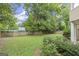 View of the backyard showcasing a green lawn, mature trees, privacy fence, and lush landscaping at 3328 Sulky Se Cir, Marietta, GA 30067