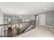 Hallway with a curved banister overlooking the foyer and a view of the living room with large windows at 3328 Sulky Se Cir, Marietta, GA 30067