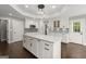 Kitchen with an island, stylish pendant lighting, white cabinets, and dark wood floors at 3328 Sulky Se Cir, Marietta, GA 30067