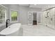 Main bathroom with a standalone tub, a glass-enclosed shower, and a large window at 3328 Sulky Se Cir, Marietta, GA 30067
