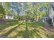 Large backyard with lush green lawn, featuring a shed, patio area with grill, and screened-in porch at 11 Frances Turn, Sharpsburg, GA 30277