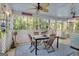 Relaxing screened porch with an outdoor dining set, ceiling fan, and views of lush greenery at 11 Frances Turn, Sharpsburg, GA 30277