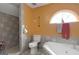 Tiled bathroom featuring a separate shower, soaking tub, window and neutral tones at 5141 Dixie Lake Rd, Union City, GA 30291