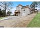 Exterior shot of home with a multi-level deck, driveway, and mature trees surrounding the property at 5141 Dixie Lake Rd, Union City, GA 30291