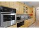 Bright kitchen features stainless steel appliances, custom cabinets with glass fronts, and tile backsplash at 5141 Dixie Lake Rd, Union City, GA 30291