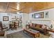 Cozy living room featuring wood plank ceiling, dining area, and comfortable seating arrangement at 5141 Dixie Lake Rd, Union City, GA 30291