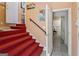 Staircase featuring red carpet and dark handrail at 5141 Dixie Lake Rd, Union City, GA 30291