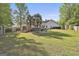 Large backyard with a wooden deck, hot tub, and lush lawn at 140 Pecan Ridge Dr, Fayetteville, GA 30215