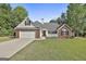 Charming single-story home with a brick facade, manicured lawn, and two-car garage at 140 Pecan Ridge Dr, Fayetteville, GA 30215