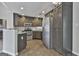 Modern kitchen boasts stainless steel appliances, granite countertops, and sleek dark cabinetry, complemented by ceramic tile flooring at 140 Pecan Ridge Dr, Fayetteville, GA 30215
