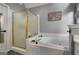 Well-lit bathroom featuring a soaking tub and glass-enclosed shower at 102 Santolina Park, Peachtree City, GA 30269