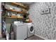 Well-organized laundry room features a washer, dryer, shelving, and attractive wallpaper at 102 Santolina Park, Peachtree City, GA 30269
