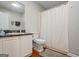 Cozy bathroom features a vanity with dark countertops and a white shower curtain over a tub at 195 Riverbend Dr, Covington, GA 30014
