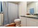 Clean bathroom with vanity, toilet, and shower featuring dark grey shower curtain at 195 Riverbend Dr, Covington, GA 30014