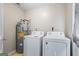 Functional laundry area with a water heater and modern washer and dryer units at 195 Riverbend Dr, Covington, GA 30014