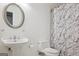 Bright bathroom with a pedestal sink, toilet, and tub with a modern patterned shower curtain at 750 Gates Ln, Alpharetta, GA 30022