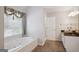 Bathroom showcasing a large tub beneath a window and a decorative sink with vanity at 750 Gates Ln, Alpharetta, GA 30022