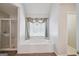 Bright bathroom featuring a large tub with decorative window treatments and a separate glass shower enclosure at 750 Gates Ln, Alpharetta, GA 30022
