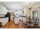 Bright eat-in kitchen features white cabinets, granite countertops, an island, and stylish chandeliers over a breakfast table at 750 Gates Ln, Alpharetta, GA 30022
