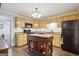 Traditional kitchen with light wood cabinetry, a central island, and black appliances at 750 Gates Ln, Alpharetta, GA 30022