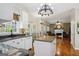 Open kitchen and living room concept with granite counters, white cabinets, hardwood floors, and stylish chandelier lighting at 750 Gates Ln, Alpharetta, GA 30022