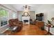 Bright living room with hardwood floors, a fireplace, a ceiling fan, and a large window, creating a cozy atmosphere at 750 Gates Ln, Alpharetta, GA 30022