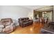 Comfortable living room with hardwood floors, a large window, and leather seating, leading to a dining area at 750 Gates Ln, Alpharetta, GA 30022