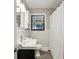 Traditional bathroom featuring tiled walls, a window, toilet and vanity with sink and mirror at 727 Channing Dr, Atlanta, GA 30318