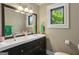 Updated bathroom with double sink vanity, framed mirror, and bright natural light from the window at 727 Channing Dr, Atlanta, GA 30318