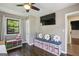 Bright bedroom features a ceiling fan, built-in bench with storage, and a wall-mounted television at 727 Channing Dr, Atlanta, GA 30318