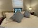 Comfortable bedroom with plush pillows, a large window, and a bedside table at 727 Channing Dr, Atlanta, GA 30318