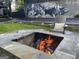 Outdoor stone firepit provides a cozy gathering space, enhanced by mural art and Adirondack chair at 727 Channing Dr, Atlanta, GA 30318