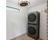 Modern laundry room features a stacked washer and dryer, updated ceiling light fixture, and wood look floors at 727 Channing Dr, Atlanta, GA 30318