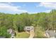 A beautiful home with a long driveway nestled among lush green trees, under a beautiful blue sky at 6435 Philips Creek Dr, Cumming, GA 30041