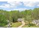 Aerial view of a charming home with two-car garage and long driveway, surrounded by lush green trees at 6435 Philips Creek Dr, Cumming, GA 30041